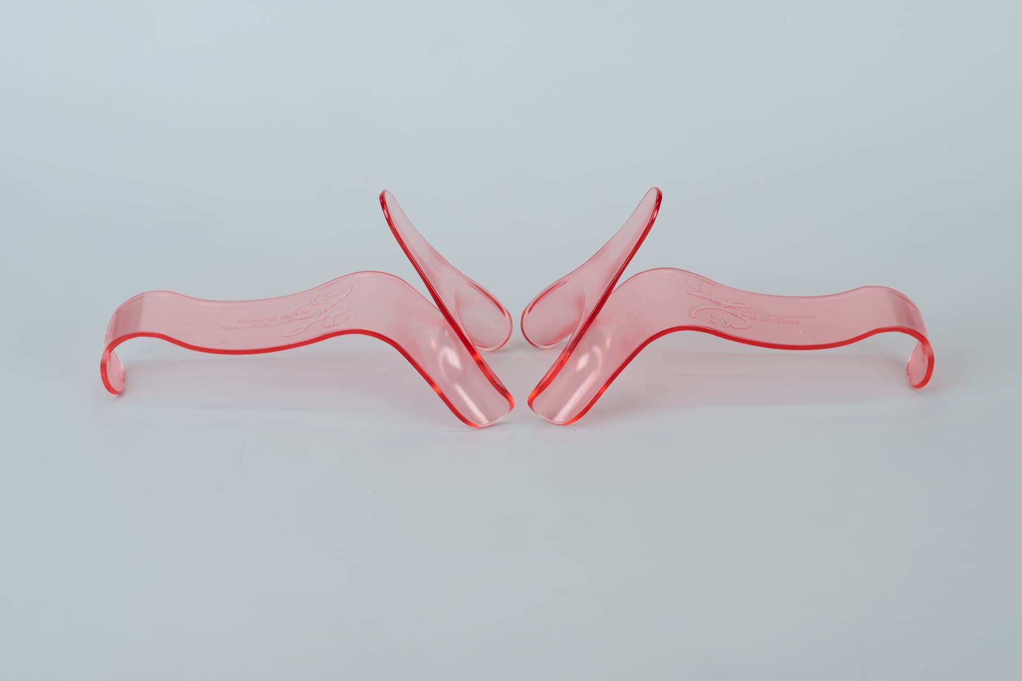 Zwei Lippen- und Wangenhalter aus transparentem, rosé Kunststoff, im Studio nebeneinander aufgenommen